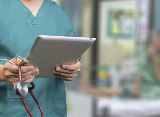 Aesthetic nurse holding ipad with software wearing a green shirt
