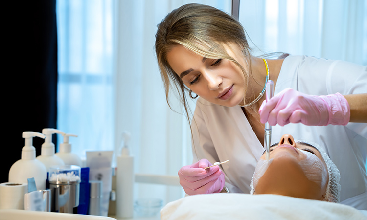 aesthetic nurse with pink gloves making a procedure